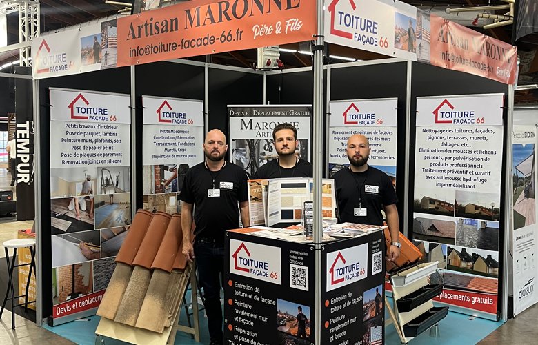 Trois hommes se tiennent au stand Toiture Façade 66 au salon Viv'Habitat de Perpignan, où sont présentés des matériaux de couverture, des brochures et des bannières contenant des informations sur l'entreprise et des photos de projets mettant en valeur leurs services de couverture et de façade.